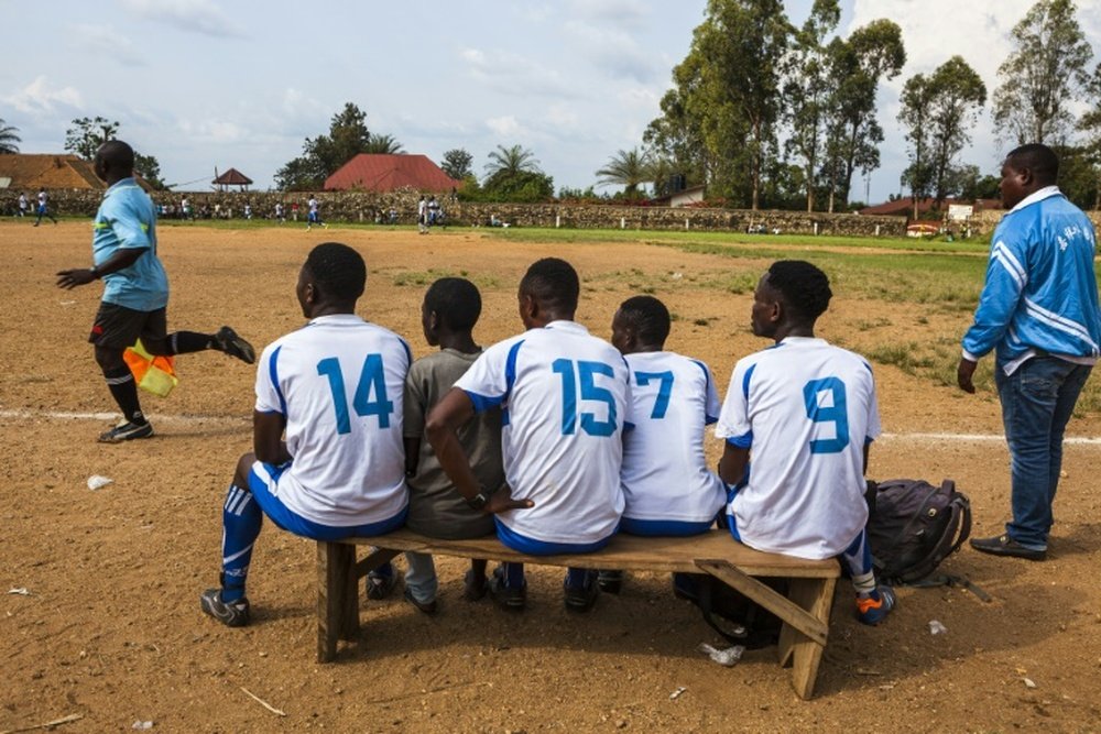 Local football players follow a match from the bench in Beni, DR Congo. AFP
