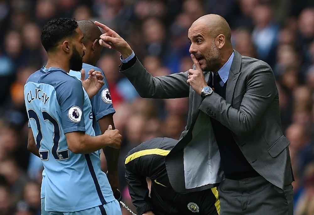 Manchester City's manager Pep Guardiola (R) gives instructions to defender Gael Clichy. AFP