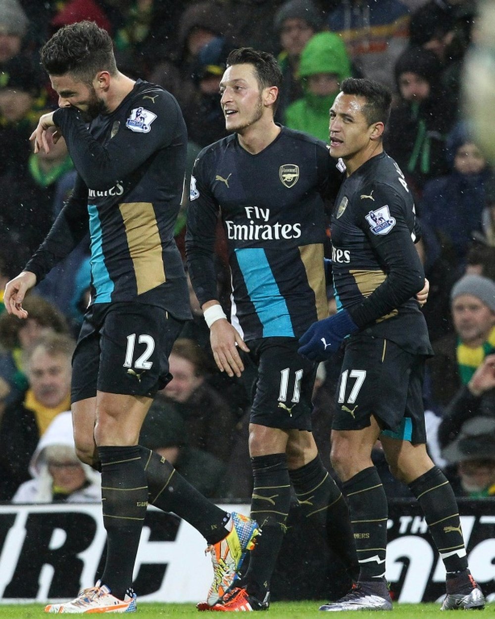 Arsenals Mesut Ozil (C) celebrates with Alexis Sanchez (R) after scoring the opening goal of the English Premier League football match between Norwich City and Arsenal at Carrow Road in Norwich, eastern England on November 29, 2015