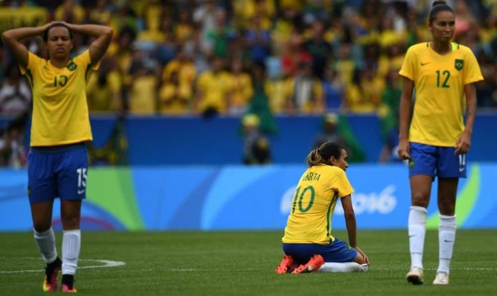 Brazils Marta (C) is dejected after losing a penalty shoot-out to Sweden in their Olympic womens semi-final football match