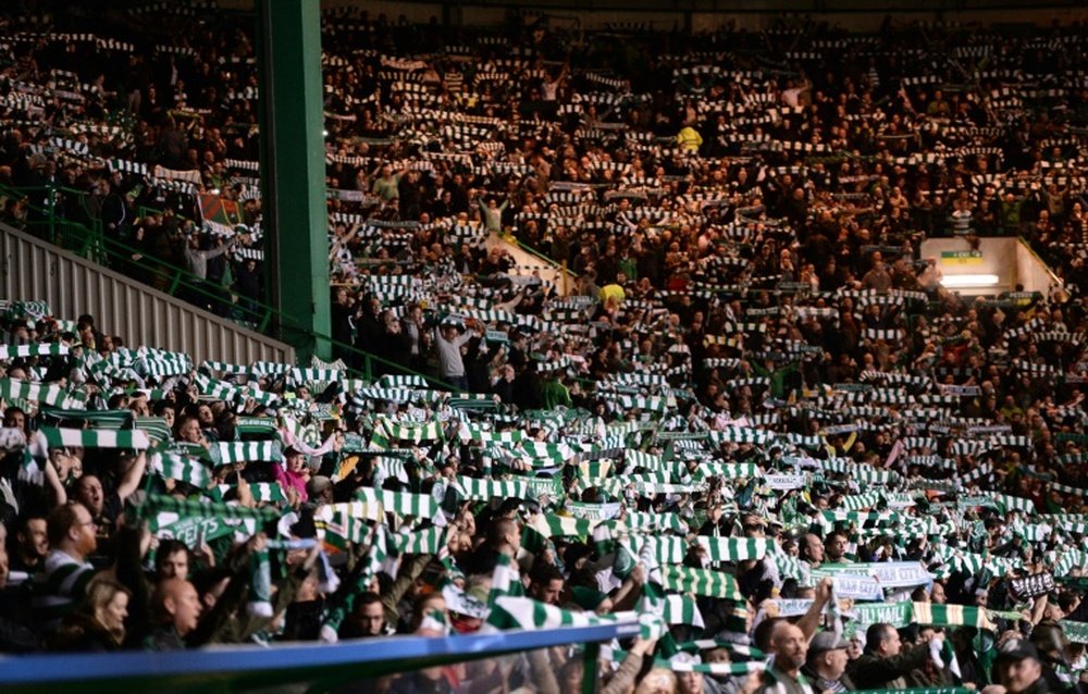 Celtic fans hold aloft scarves at Celtic Park stadium in Glasgow. AFP