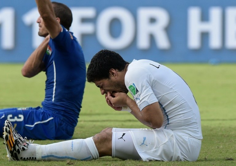 Suarez went down clutching his teeth after digging them into Chiellini. AFP