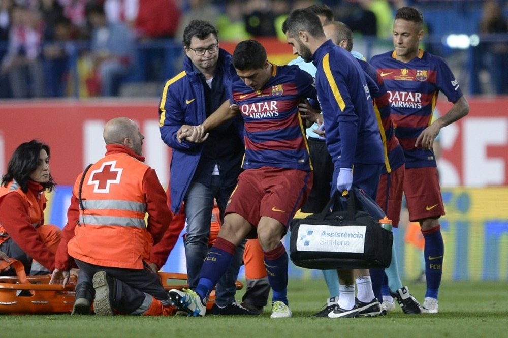 Barcelonas Uruguayan forward Luis Suarez (C) is assited after being injured during the Spanish Copa del Rey (Kings Cup) final match against Sevilla FC at the Vicente Calderon stadium in Madrid on May 22, 2016