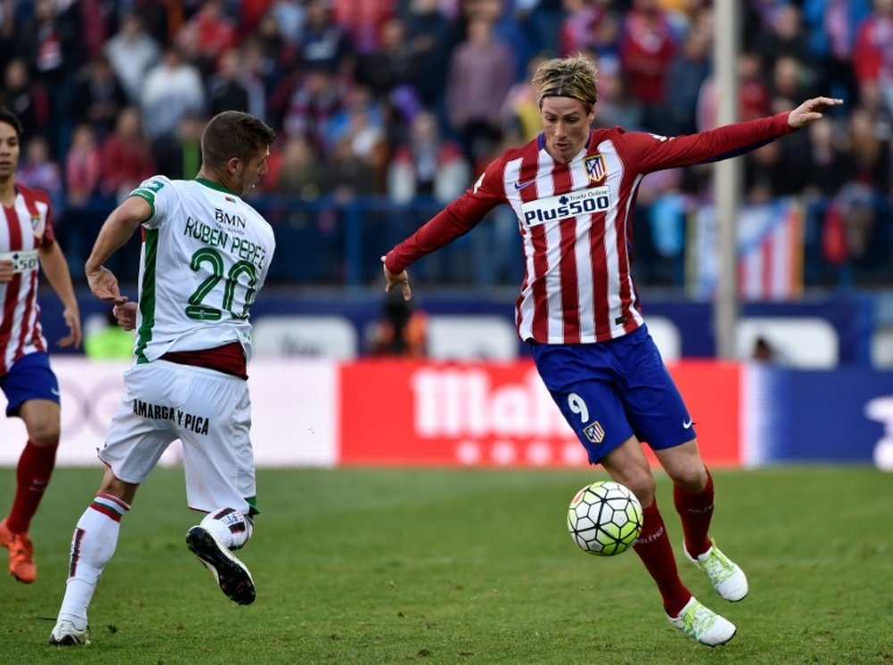 Atletico Madrids forward Fernando Torres (L) tries to control a ball beside Granadas midfielder Ruben Perez on April 17, 2016