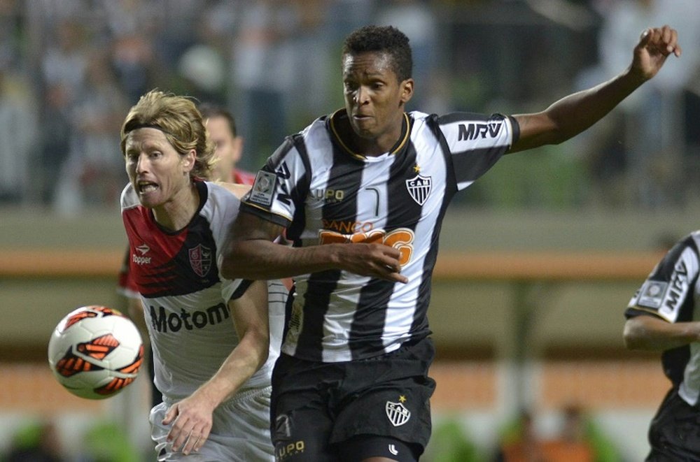 Milton Casco (left), of Argentinas Newells Old Boys, vies for the ball with Jo, of Brazils Atletico Mineiro, during their 2013 Copa Libertadores second leg semifinal football match at Arena Independencia Stadium in Belo Horizonte, on July 10, 2013