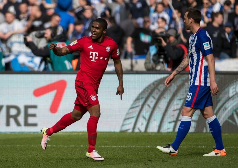 Bayern Munichs Brazilian midfielder Douglas Costa celebrates scoring his sides second goal during the German first division Bundesliga football match against Hertha BSC in Berlin, on April 23, 2016