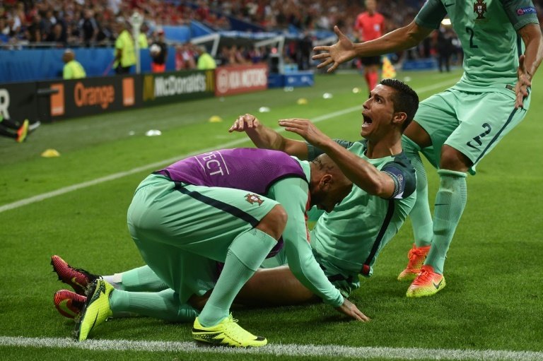 Portugals forward Cristiano Ronaldo celebrates with teammates after scoring a goal during their Euro 2016 semi-final match against Wales, at the Parc Olympique Lyonnais stadium in Decines-Charpieu, on July 6