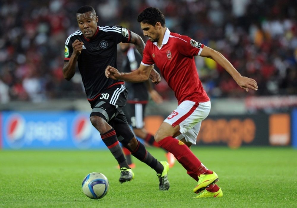 Orlando Pirates Thamsanqa Gabuza (L) vies with Al Ahlys Mohamed Naguib during the first semi final of the 2015 CAF - Confederation of African Football Cup on September 26, 2015 at the Orlando Pirates Stadium in Johannesburg, South Africa