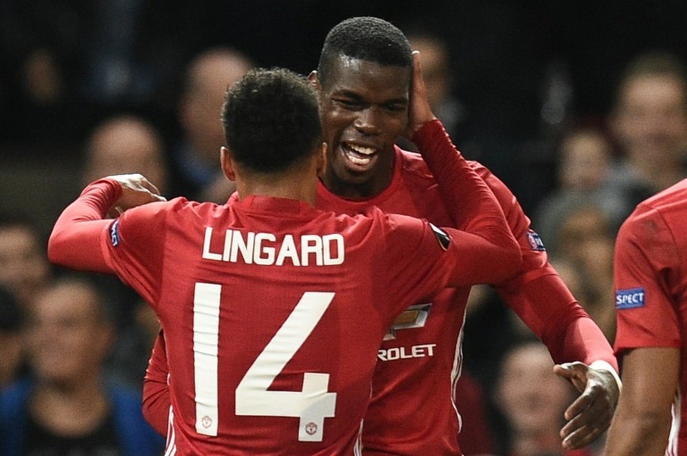 Manchester Uniteds Paul Pogba (R) and Jesse Lingard (L) celebrate after Pogba scored their third goal against Fenerbahce in Manchester, on October 20, 2016.