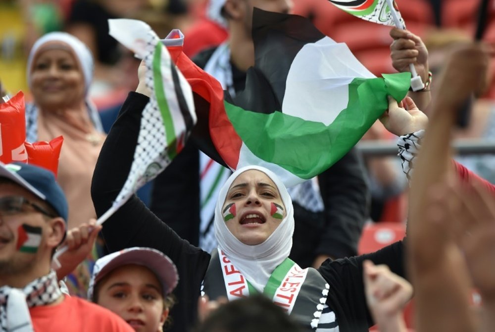 Palestinian fans cheer before a match on January 12, 2015