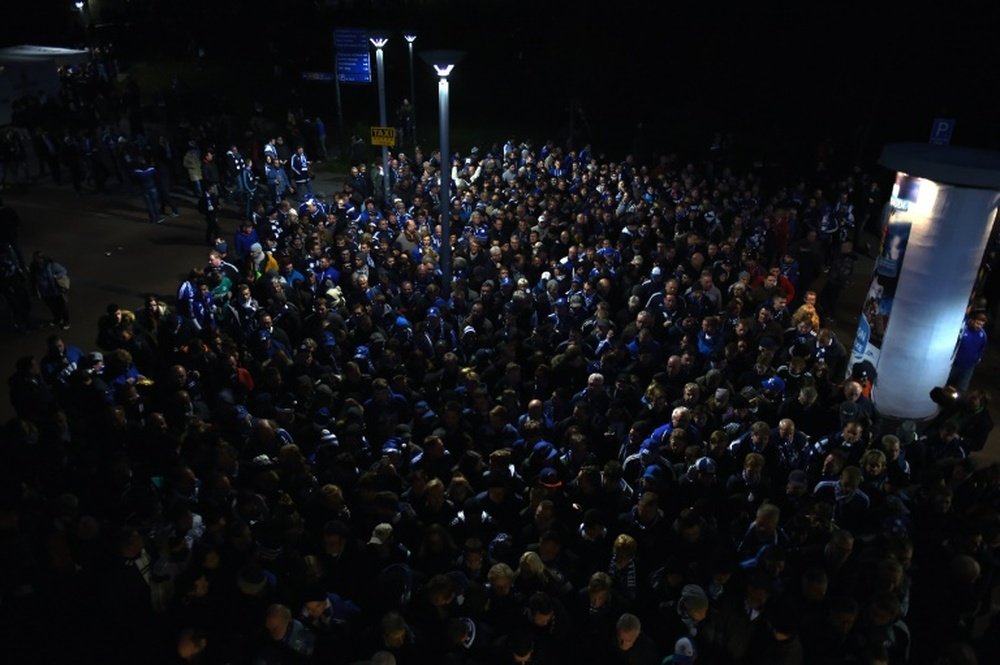 Visitors wait in a queue for a security check at the entrance of the stadium prior to the German first division Bundesliga football match FC Schalke 04 vs FC Bayern Munich in Gelsenkirchen, western Germany, on November 21, 2015