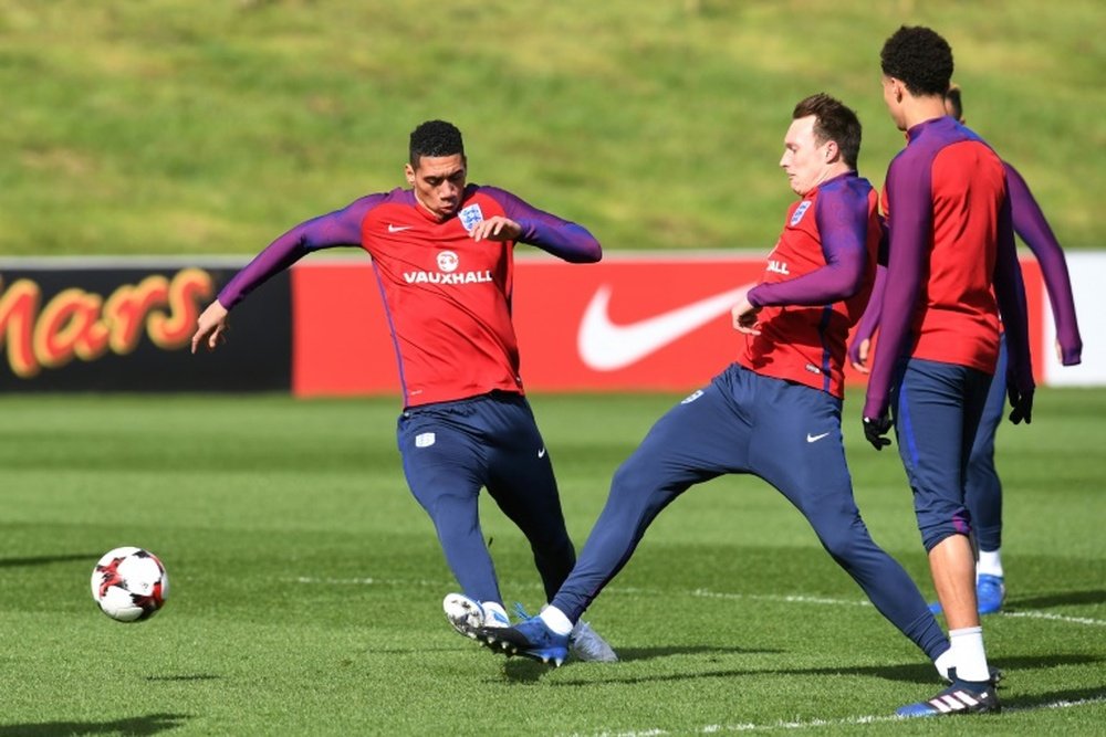 England defender Chris Smalling (L) and teammate Phil Jones take part in a training session at St Ge