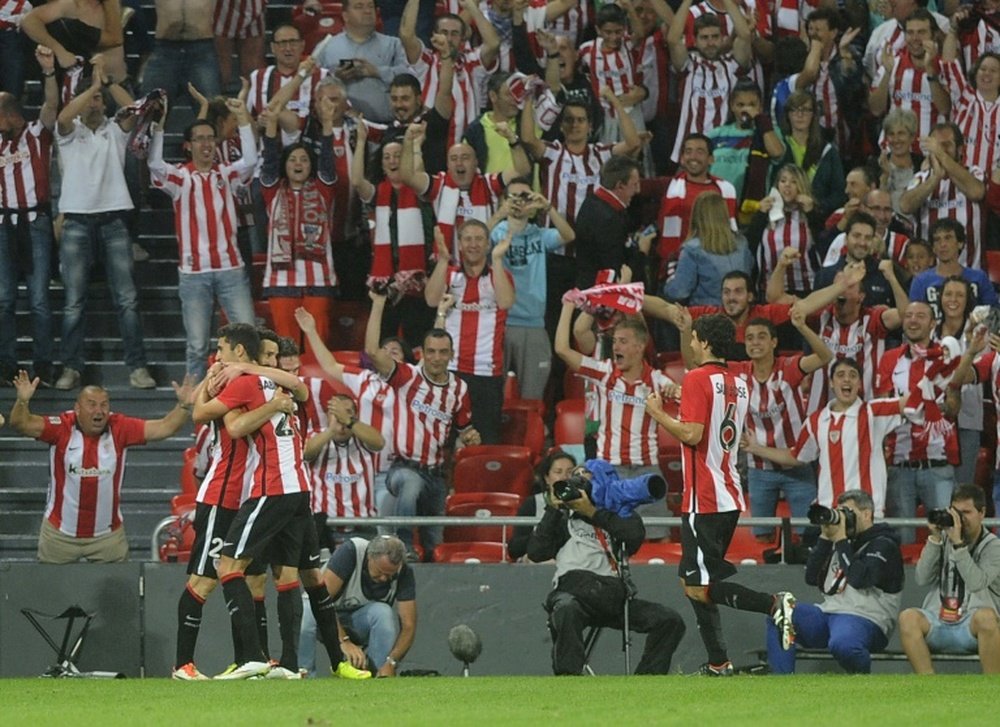 Athletic Bilbaos forward Aritz Aduriz (L) is congratulated by teammates after scoring their teams fourth goal during the Spanish Supercup first-leg football match Athletic Club Bilbao vs FC Barcelona in Bilbao on August 14, 2015