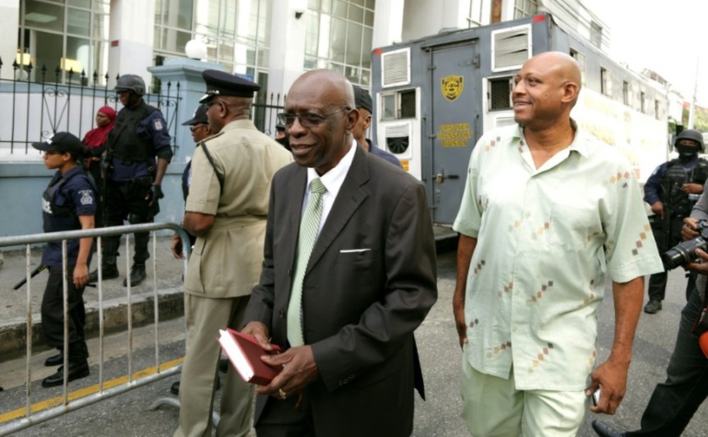 Former FIFA vice-president Jack Warner (C) is accompanied by his bodyguard (R), as he leaves the Port-of-Spain Magistrates court in the capital city of Trinidad, after an extradition hearing on July 27, 2015