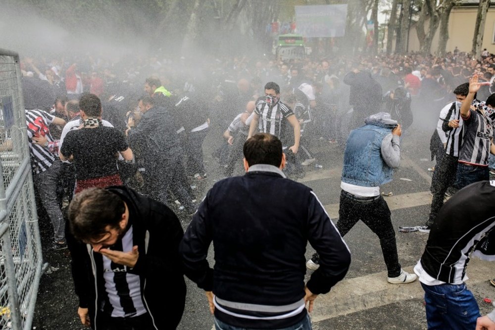 Turkish anti-riot police use tear gas and water cannon to disperse supporters of Besiktas around the stadium on April 11, 2016 in Istanbul