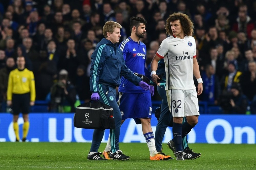 Paris Saint-Germains defender David Luiz (R) shakes hands as Chelseas striker Diego Costa (C) leaves the pitch after getting injured during the UEFA Champions League round of 16 second leg football match in London on March 9, 2016
