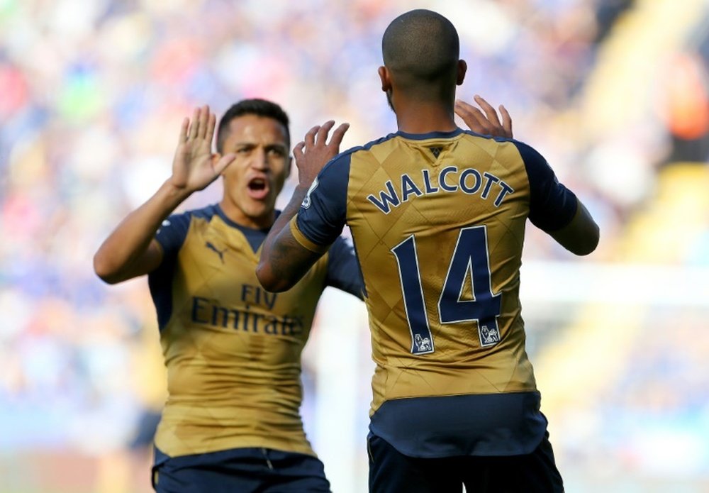 Arsenals Theo Walcott (R) celebrates with teammate Alexis Sanchez after scoring on September 26, 2015