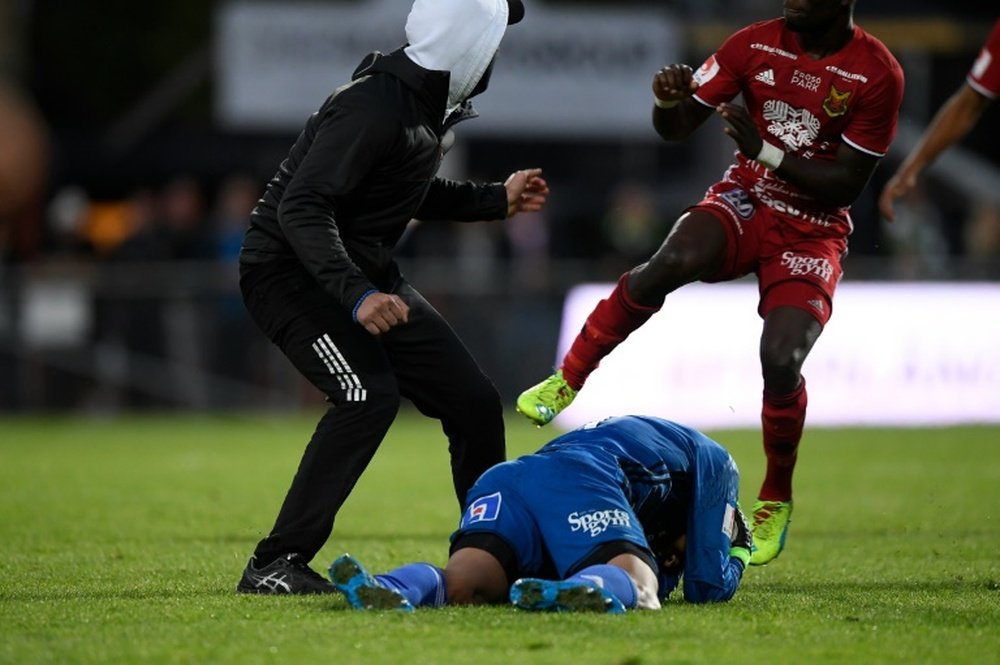 Ostersund's Aly Keita lies on the ground after a masked spectator attacked him during a match. AFP