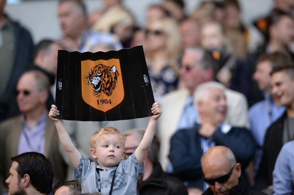 A young Hull City fan holds up a banner in the crowd before an English Premier League football match in Kingston upon Hull, England on May 24, 2015