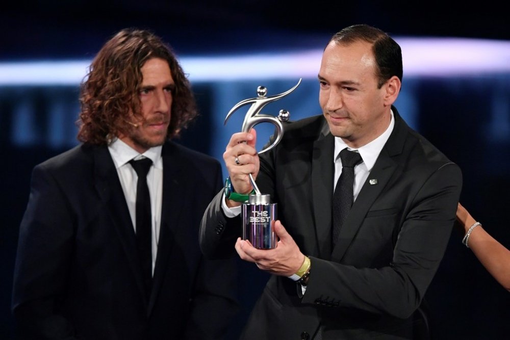 Colombian executive and chairman of Atletico Nacional Juan Carlos de la Cuesta (R) holds The 2016 FIFA Fair Play Award next to former Spanish football player Carles Puyol during The Best FIFA Football Awards ceremony, on January 9, 2017 in Zurich