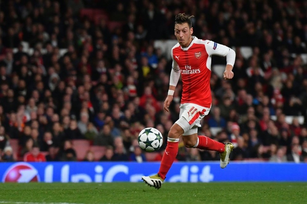 Arsenal midfielder Mesut Ozil shoots to score his hat trick and his teams sixth goal. AFP