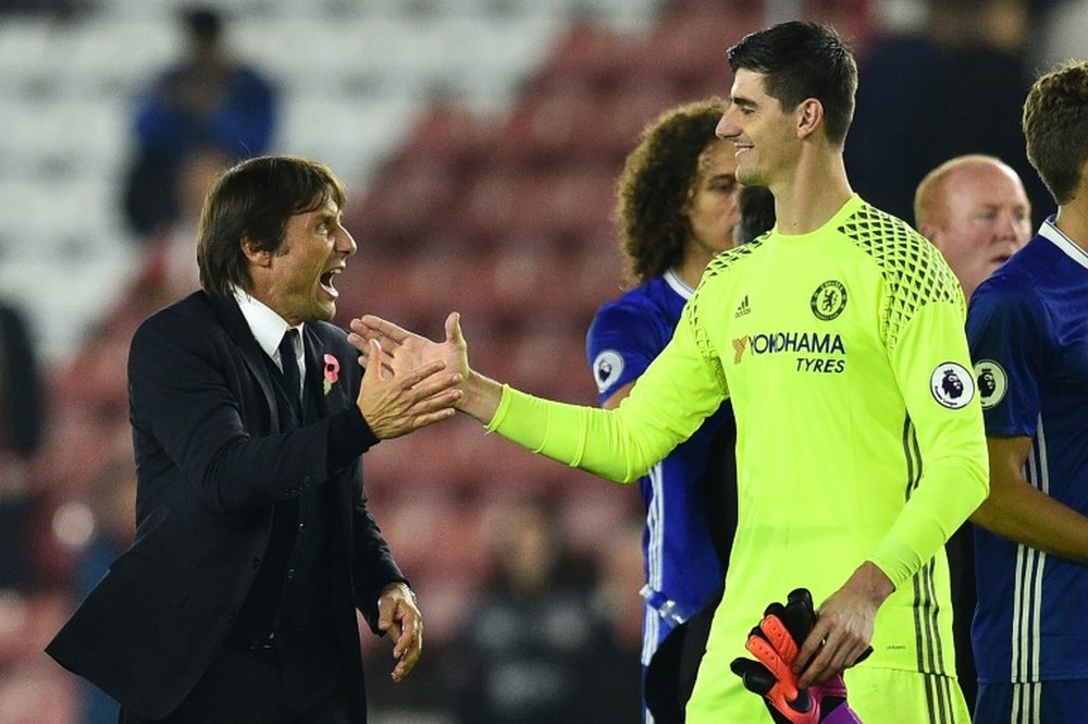 Antonio Conte serre la main à Thibaut Courtois lors d'une célébration. AFP