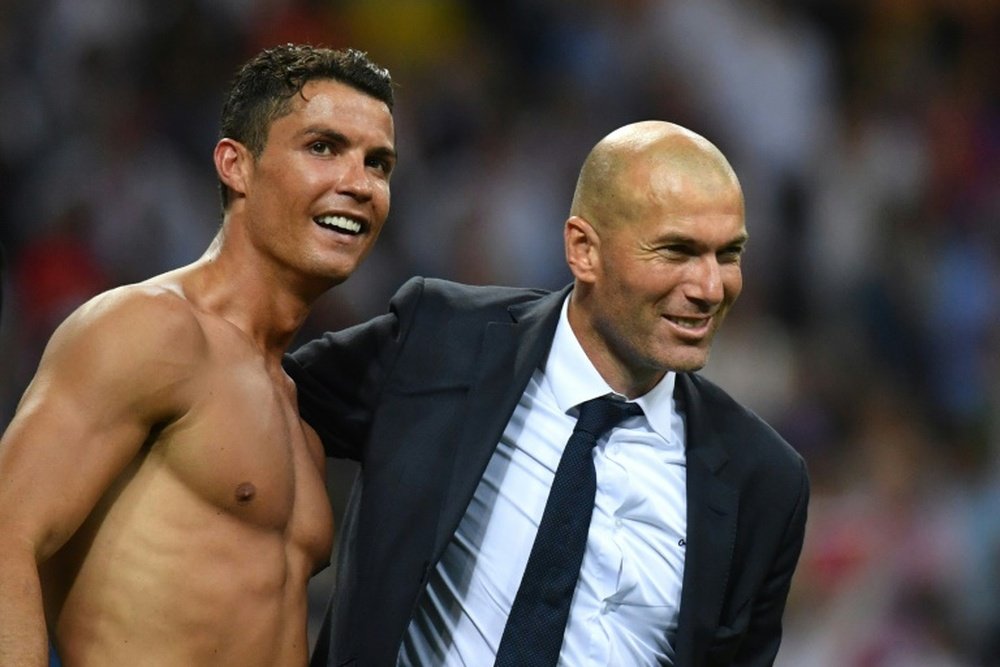 Real Madrids forward Cristiano Ronaldo (L) and coach Zinedine Zidane celebrate after Real won the UEFA Champions League final over Atletico Madrid at San Siro Stadium in Milan, on May 28, 2016