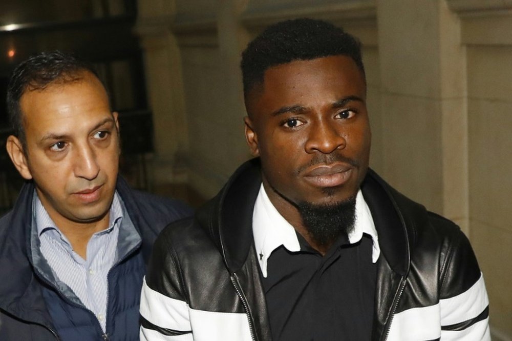 Paris Saint-Germain defender Serge Aurier (R) arrives at the Paris courthouse where he was jailed and fined for elbowing a police officer, on September 26, 2016