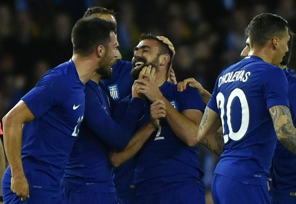 Greek midfielder Ioannis Maniatis (centre) is mobbed by his team-mates after scoring. BeSoccer