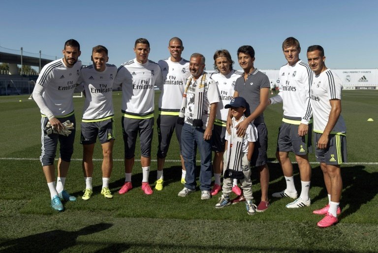 Osama Abdul Mohsen (C) and his sons Mohammad (3R) and Zaid (front) pose with (from L) Real Madrids Kiko Casilla, Denis Cheryshev, Cristiano Ronaldo, Pepe, Luka Modric, Toni Kroos and Lucas at the training ground in Madrid on September 18, 2015