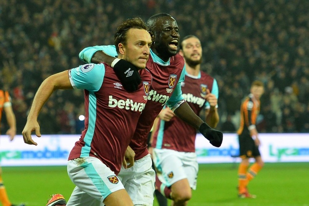 West Ham Uniteds English midfielder Mark Noble (L) celebrates after scoring the opening goal from the penalty spot during a match against Hull City at The London Stadium on December 17, 2016