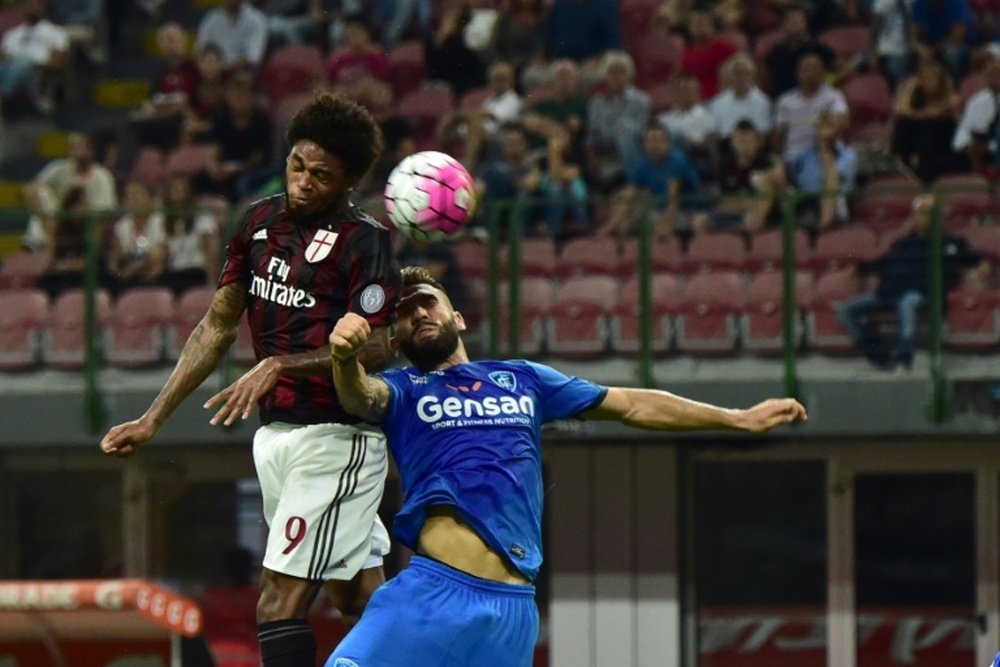 AC Milans forward from Brazil Luiz Adriano (L) jumps for the ball during the Italian Serie A football match between AC Milan and Empoli at San Siro Stadium in Milan on August 29, 2015