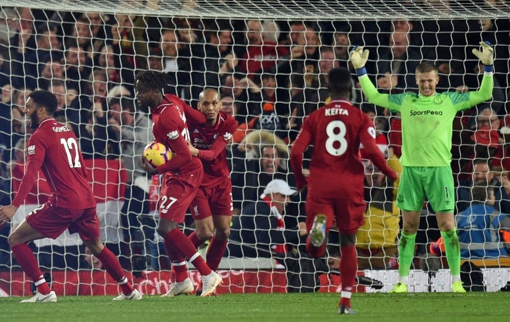 Liverpool players celebrate Divock Origi's late winning goal against Everton. AFP