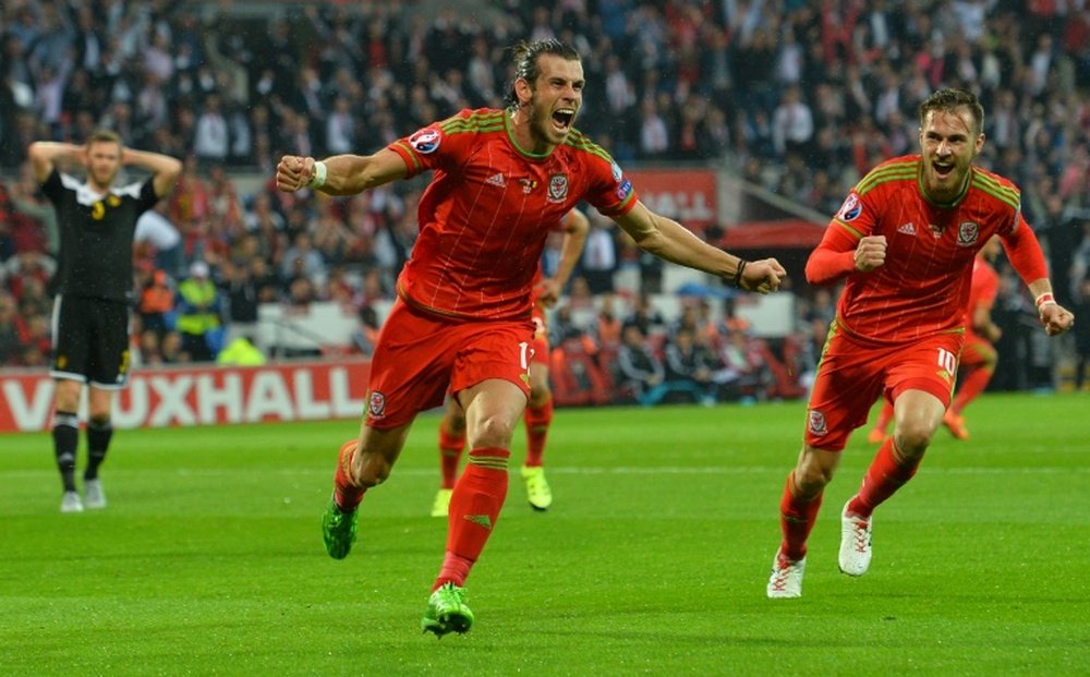 Waless midfielder Gareth Bale (centre) celebrates scoring the opening goal with Waless midfielder Aaron Ramsey during the Euro 2016 qualifying match between Wales and Belgium at Cardiff City Stadium in Cardiff on June 12, 2015