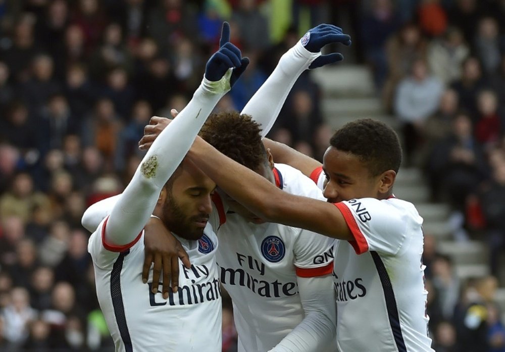 Paris Saint-Germains midfielder Lucas Moura (L) celebrates with teammates after scoring a penalty kick during the French L1 football match between Guingamp and Paris-Saint-Germain on April 9, 2016 in Guingamp, France