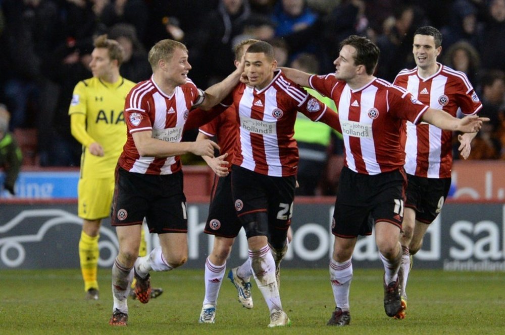 Sheffield Uniteds Che Adams (C) celebrates after scoring his teams second goal during the League Cup semi-final second leg match against Tottenham Hotspur at Bramall Lane on January 28, 2015