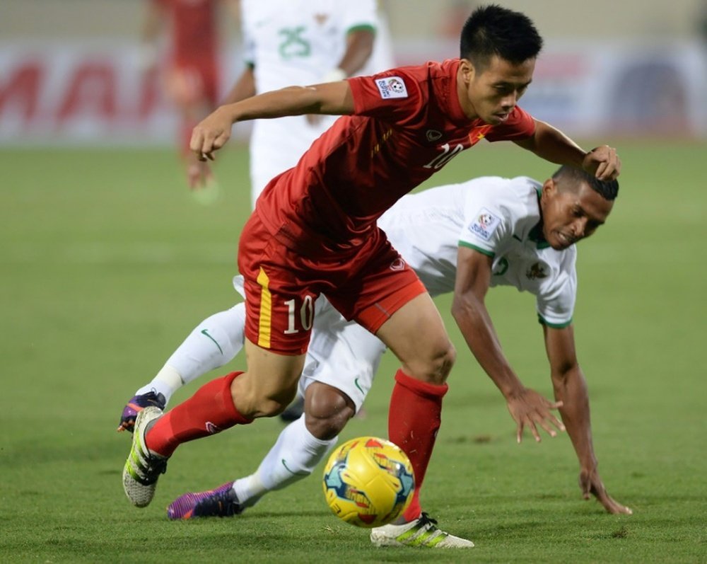 Vietnam's Nguyen Van Quyet (left) fights for the ball with Indonesia's Lestaluh. AFP