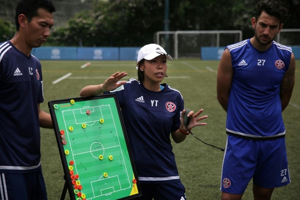 Head coach of Eastern FC, Chan Yuen-ting, talks to her players during a training session. AFP