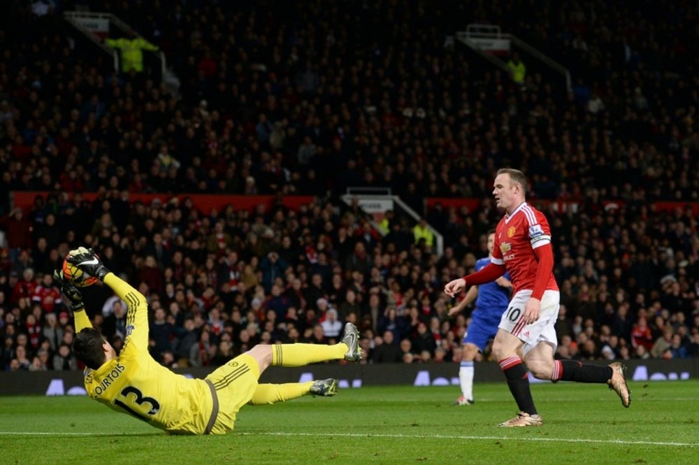 Chelseas goalkeeper Thibaut Courtois (L) makes a save in front of Manchester Uniteds striker Wayne Rooney (R), during the English Premier League football match at Old Trafford in Manchester, England, on December 28, 2015