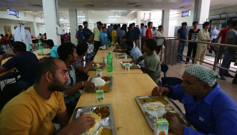 Foreign workers have lunch at the cafeteria of the new labour city in Doha