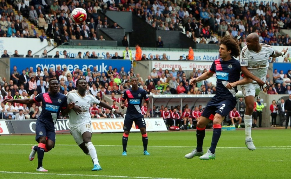 Swansea Citys French-born Ghanaian striker Andre Ayew (R) scores from a header past Newcastle Uniteds Argentinian defender Fabricio Coloccini during the English Premier League football match in Swansea, south Wales on August 15, 2015