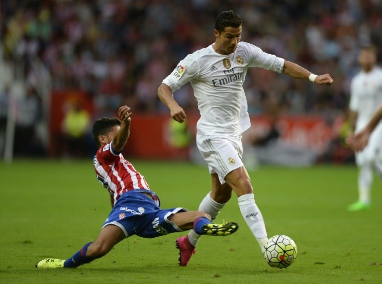 Real Madrids Portuguese forward Cristiano Ronaldo (R) vies with Sporting Gijons midfielder Nacho Cases during the Spanish league football match at the El Molinon stadium in Gijon on August 23, 2015