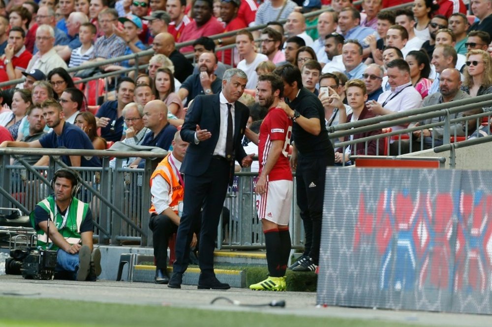 Mourinho explains his decision to Juan Mata. AFP