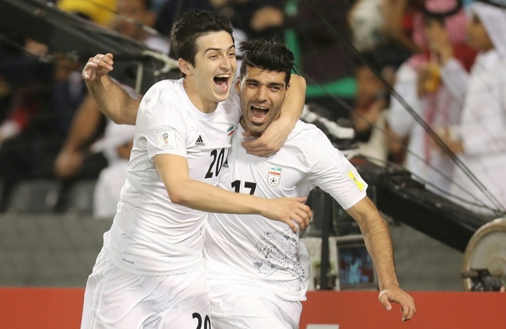 Irans Mehdi Taremi (R) celebrates with teammate Sardar Azmoun (L) after scoring a goal against Qata