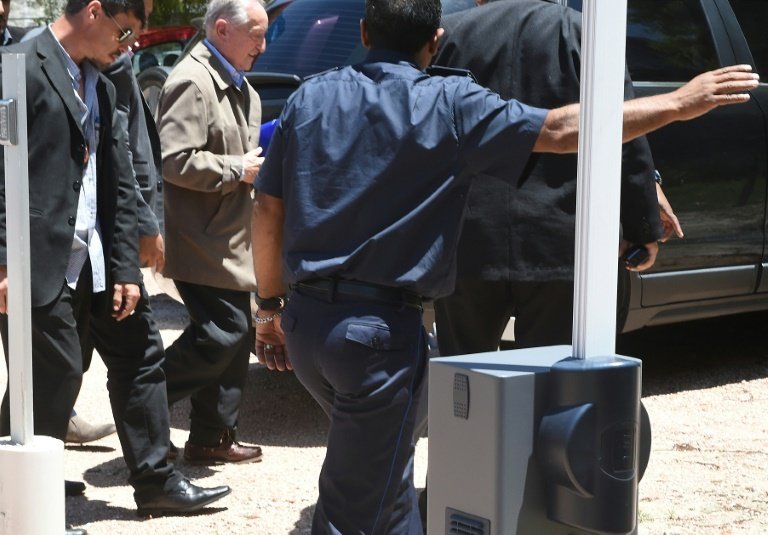 FIFA ex-vice president Eugenio Figueredo (C, tan jacket), is escorted as he arrives at the court in Montevideo on December 24, 2015