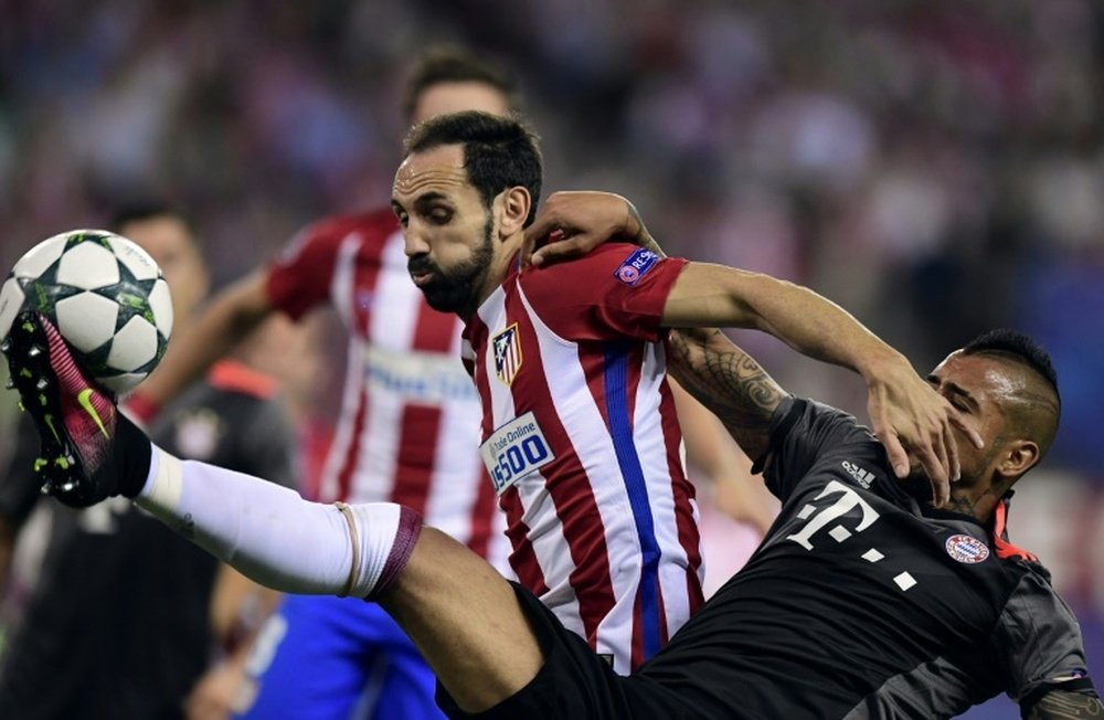 Atletico Madrids defender Juanfran (R) vies with Bayern Munichs Chilean midfielder Arturo Vidal during the UEFA Champions League Group D football match in Madrid on September 28, 2016