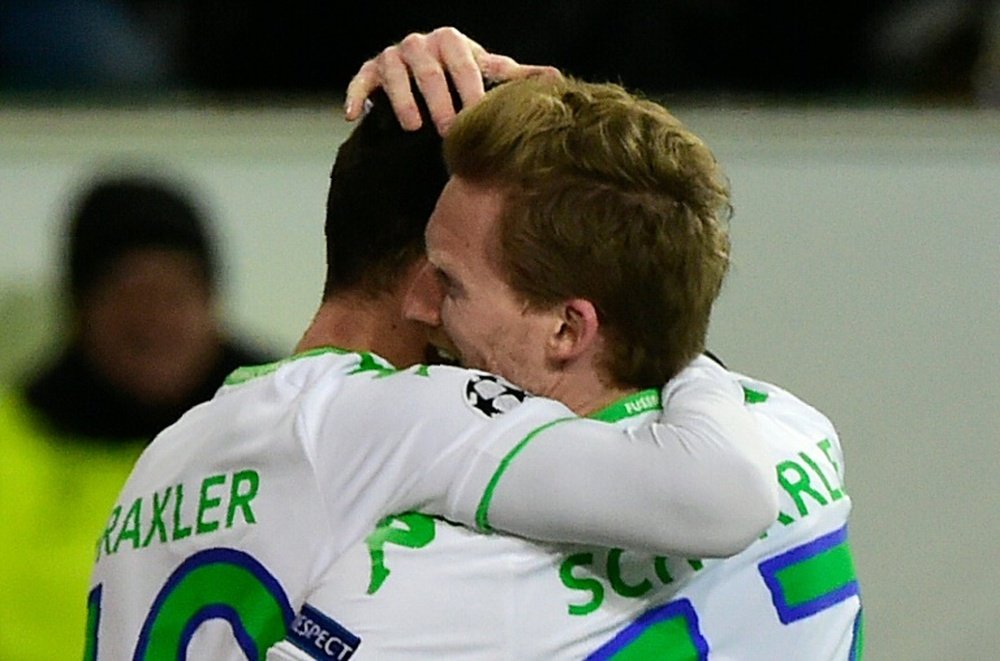 Wolfsburgs striker Andre Schuerrle (R) and Julian Draxler react after scoring during a UEFA Champions League match against Gent at the Volkswagen arena in Wolfsburg on March 8, 2016