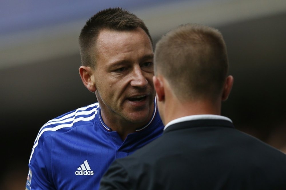 Chelsea defender John Terry (L) talks with assistant referee Harry Lennard after Chelsea goalkeeper Thibaut Courtois was sent off during their English Premier League game against Swansea City at Stamford Bridge in London on August 8, 2015