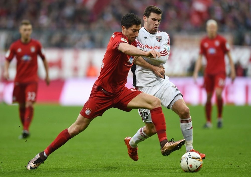 Bayern Munichs Polish striker Robert Lewandowski (left) and Ingolstadts midfielder Pascal Gross vie for the ball during their Bundesliga match in Munich on December 12, 2015