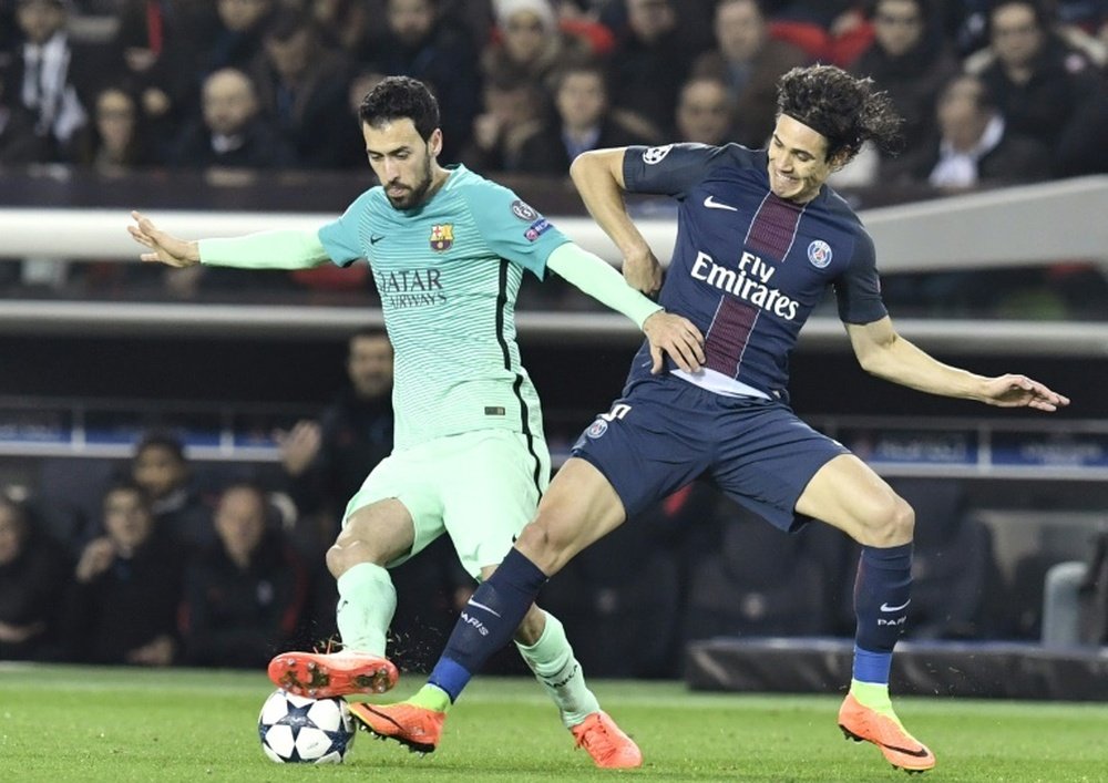 Barcelonas midfielder Sergio Busquets vies with Paris Saint-Germains forward Edinson Cavani